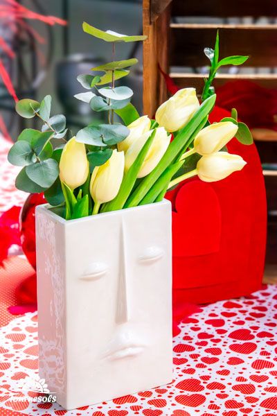 Tulipes multicolores fraîchement coupées dans un vase en verre sur une table en bois, décoration printanière